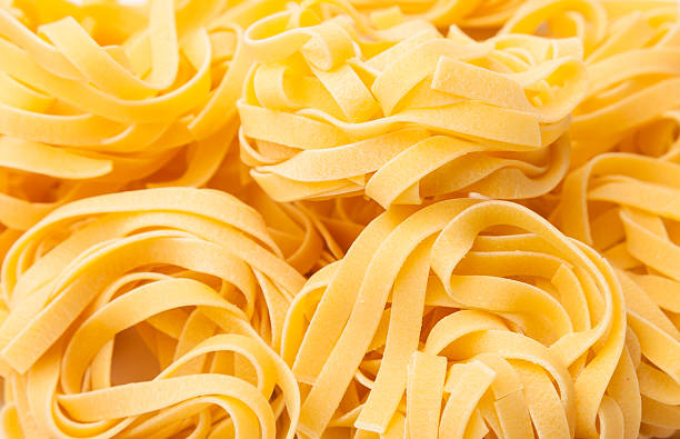 Italian pasta close background of Italian pasta tagliatelle. tagliatelle stock pictures, royalty-free photos & images