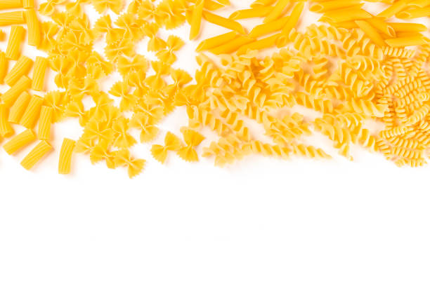 Italian pasta texture, flatlay banner, overhead shot on a white background with copyspace. Fusilli, farfalle, penne and other types  uncooked pasta stock pictures, royalty-free photos & images