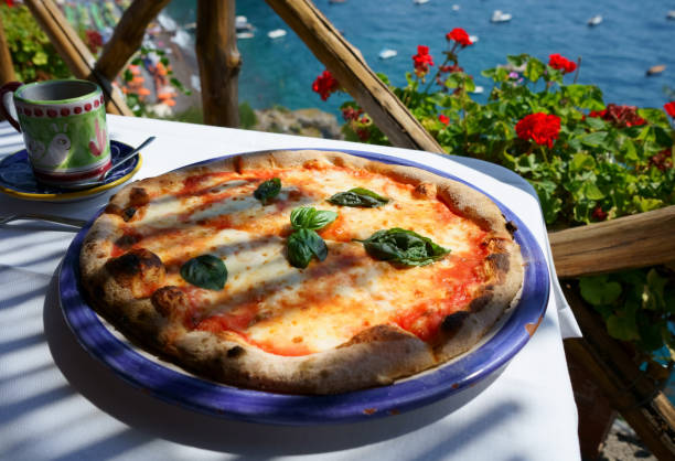 pizza italiana margarita servita sulla terrazza con vista sul mare - napoli genoa foto e immagini stock