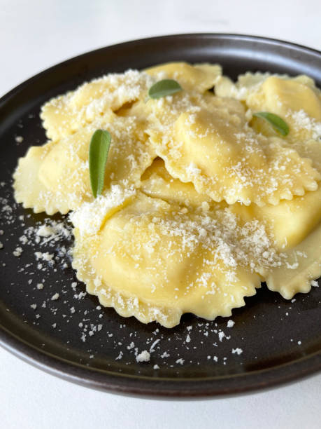 italian ravioli with parmesan cheese and sage stock photo