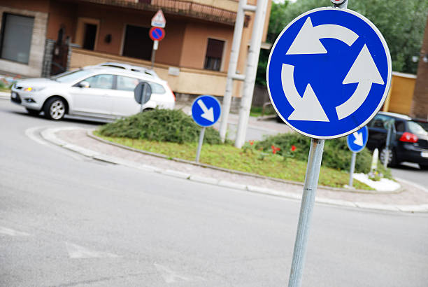 Italian roundabout sign with defocussed cars Italian roundabout sign with defocussed cars give way at roundabout stock pictures, royalty-free photos & images