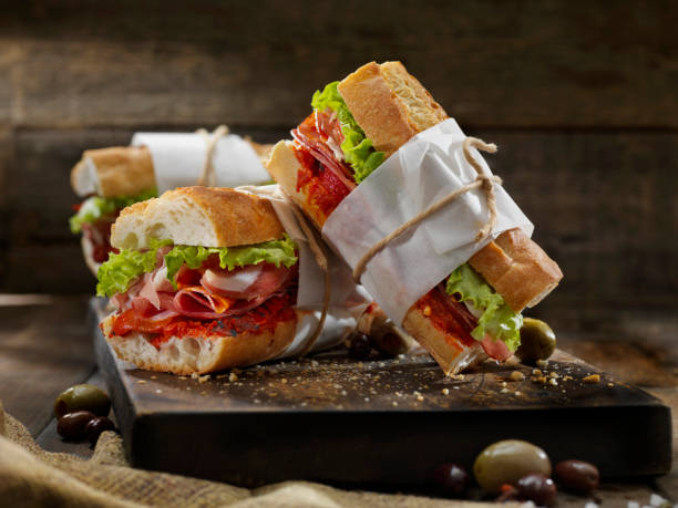 italienische sandwichs mit gerösteten roten paprika - baguette stock-fotos und bilder