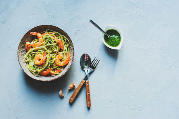 Italian vegetarian dinner. Spaghetti with prawn in homemade pesto sauce. Tasty shrimp pasta. stock photo
