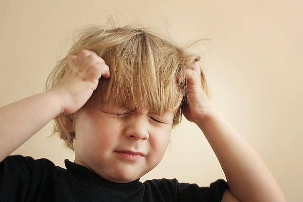 Itchy Scalp from Head Lice A four year old boy scratching his head Please see some similar images from my portfolio : headache kid stock pictures, royalty-free photos & images