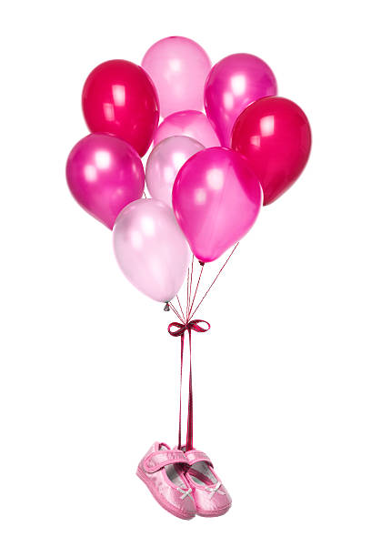 It's a girl! Pink Balloons fly with  shoes of newborn isolated on white background it's a girl stock pictures, royalty-free photos & images