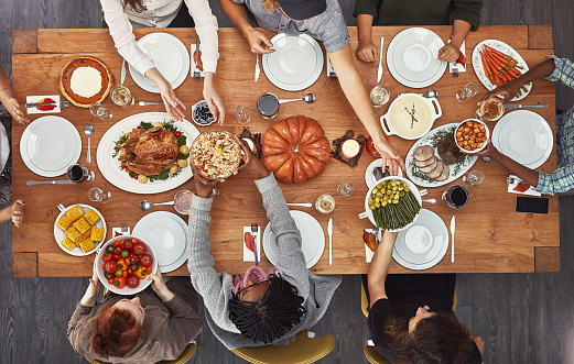 Shot of a group of people sitting together at a dining table ready to eat