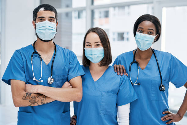 It's our aim to get you to optimum health Portrait of a group of medical practitioners wearing face masks in a hospital nurse photos stock pictures, royalty-free photos & images