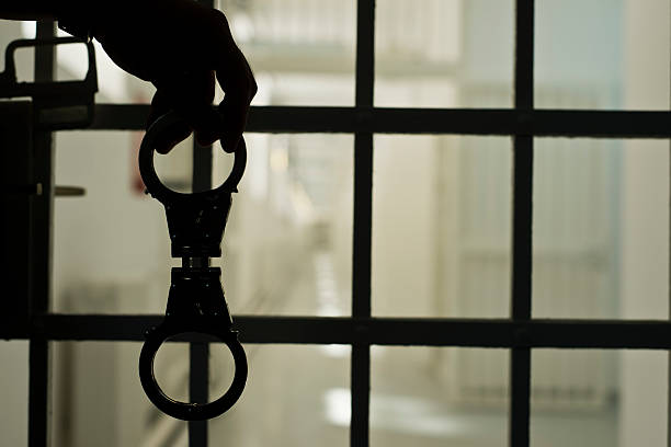 Jail Close up of  silhouette handcuffs in prison sentencing stock pictures, royalty-free photos & images