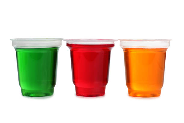 Jam in plastic cups Jam in plastic with raw fruit on white background gelatin stock pictures, royalty-free photos & images