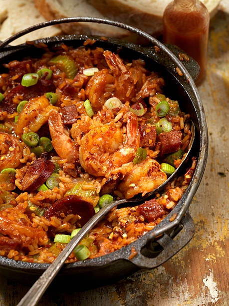 Jambalaya "Creole Style Shrimp and Sausage Jambalaya in a cast iron pot with Hot sauce, corn bread- Photographed on Hasselblad H3D2-39mb Camera" gumbo stock pictures, royalty-free photos & images
