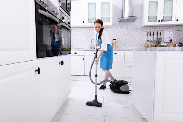 Janitor Cleaning Kitchen Floor With Vacuum Floor Young Female Janitor In Uniform Cleaning Kitchen Floor With Vacuum Floor maid stock pictures, royalty-free photos & images