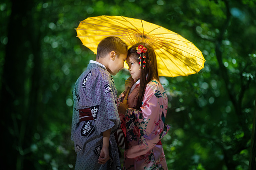 Japanese american sibling under umbrella