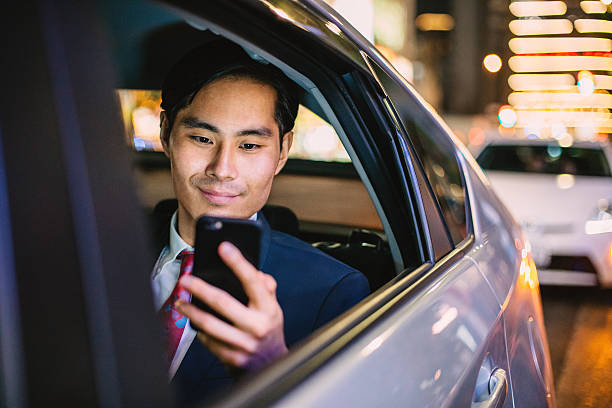 japanese businessman in a car at the night - pakjesavond stockfoto's en -beelden