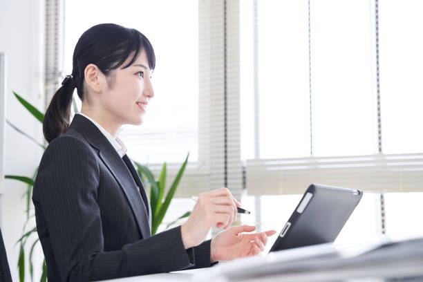 日本の女性ビジネスウーマンがオフィスでタブレットを使って面接を行う - インタビュー　日本人 ストックフォトと画像