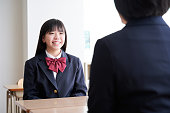 日本の中学生の女の子が教室で先生と会う