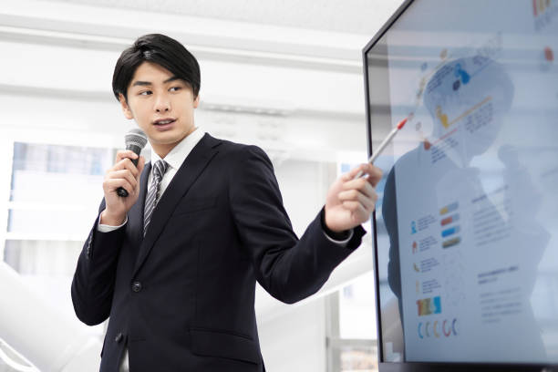 A Japanese male businessman A Japanese male businessman giving a presentation. japanese ethnicity stock pictures, royalty-free photos & images