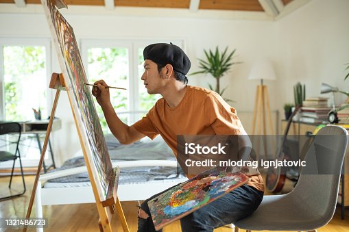 istock Japanese man spending weekend morning painting in his bedroom at home 1321486723