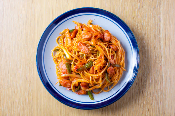 Japanese pasta dish, spaghetti (Naporitan) recipe. Naporitan on a plate is placed on a light wood grain table. stock photo