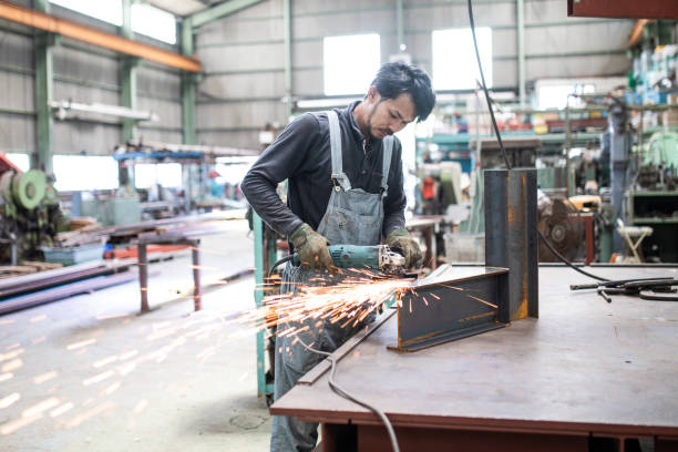 Japanese steel factory worker man grinding a girder stock photo