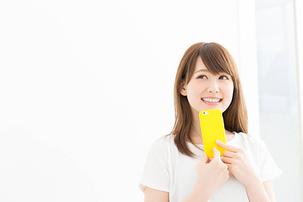 スマートフォンを持つ日本人女性 - スマホ　女性　日本人 ストックフォトと画像