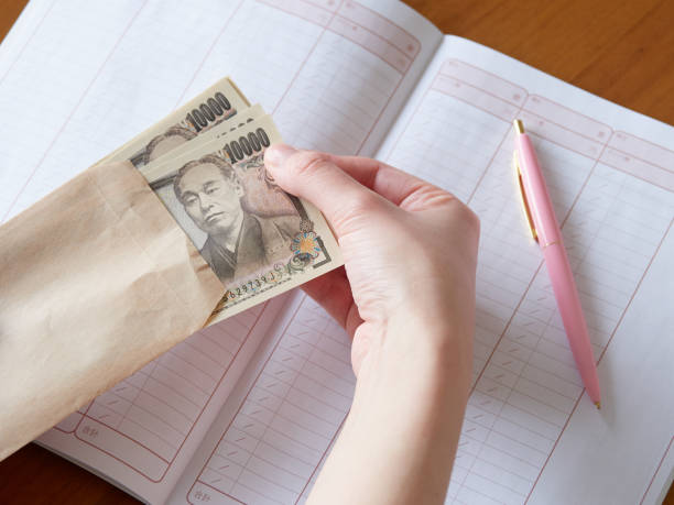 Japanese women filling in their household accounts A Japanese woman's hand filling out a household account allowance stock pictures, royalty-free photos & images