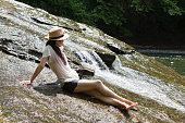 日本の女性は、渓流でリラックスします。