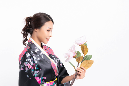 Beautiful attractive asian woman wearing traditional japanese kimono with a bouquet of beautiful flowers isolated on white background