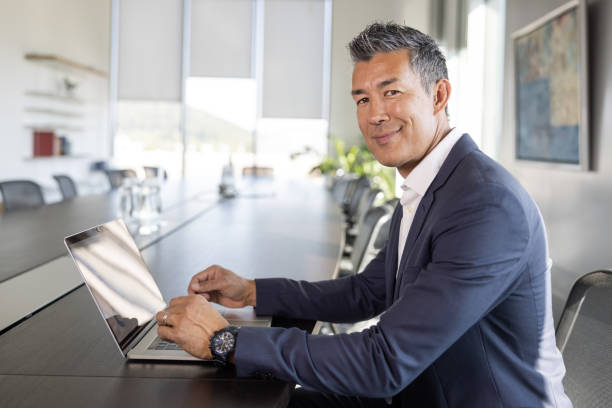 Japanese-American businessman at a desk a laptop stock photo