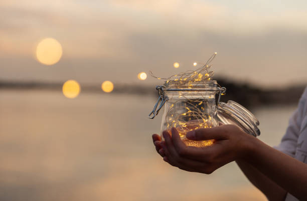 Jar with lights on the beach in summer sunset. Sunset colors. Selective focus. stock photo