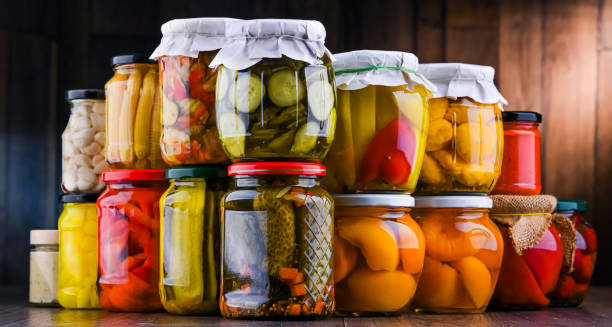Jars with variety of marinated vegetables and fruits stock photo