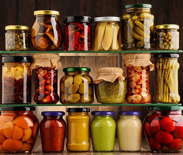 Jars with variety of pickled vegetables. stock photo