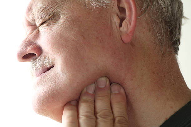 Jaw pain in older man stock photo