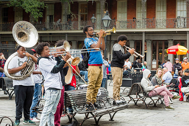Jazz Musicians Busk in Jackson Square, New Orleans New Orleans, USA - November 8, 2015: A group of young men play jazz music as people sit in Jackson Square in the French Quarter of New Orleans, Louisiana. theasis stock pictures, royalty-free photos & images