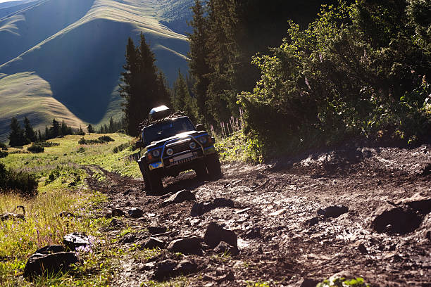 jeep navigating rough terrain during an off-road drive - extreem terrein stockfoto's en -beelden