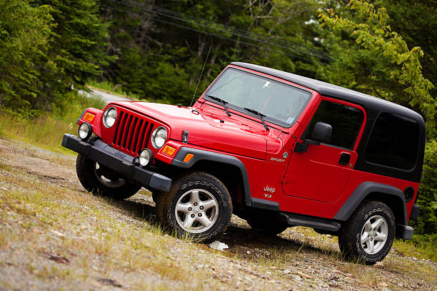 Jeep Wrangler TJ sitting on muddy dirt and gravel trail stock photo