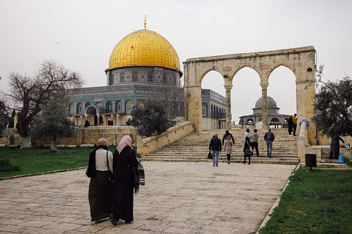 Jerusalem, Israel - 03 24 2018: Palestinian people walking at Dome of the Rock temple mosque Jerusalem old city.