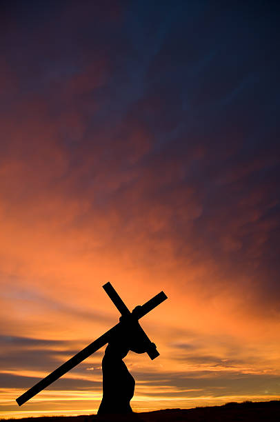 jésus portant la croix et orange coucher du soleil. vertical - good friday photos et images de collection