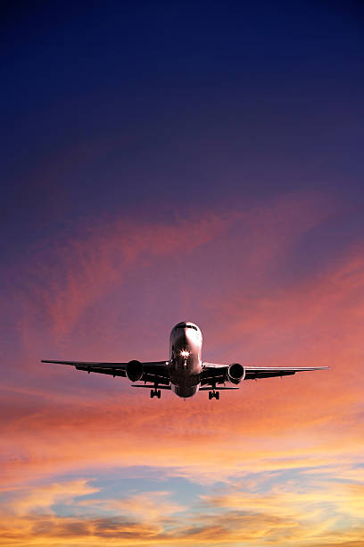 XL jet airplane landing at sunset stock photo