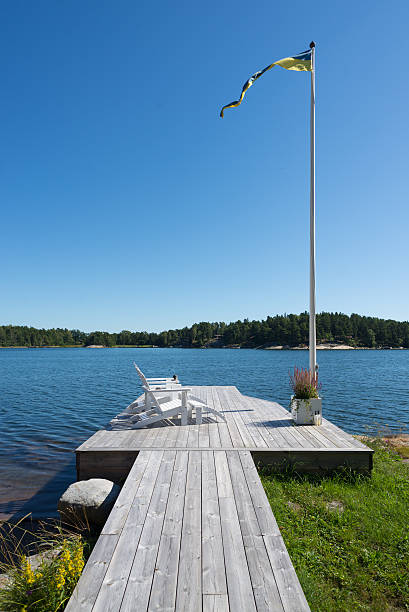Jetty with sunbeds and flagpole on Swedish island stock photo