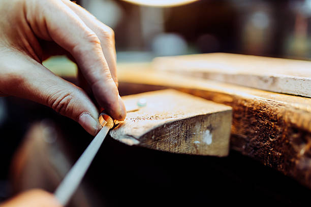 Jeweler crafting jewelry Jeweler crafting jewelry on his workbench gold ring on finger stock pictures, royalty-free photos & images