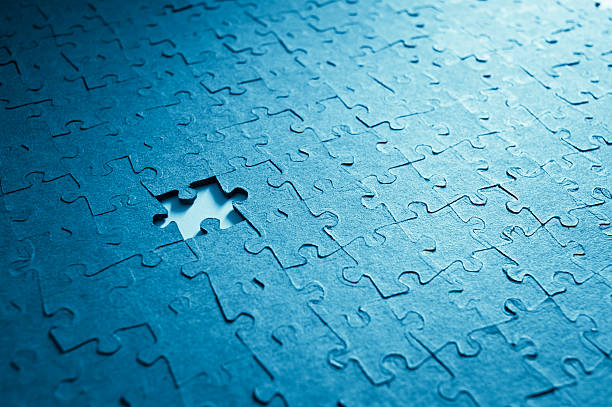 Jigsaw Puzzle And Missing Piece Jigsaw puzzle close up. Blue tone for the mood. incomplete stock pictures, royalty-free photos & images