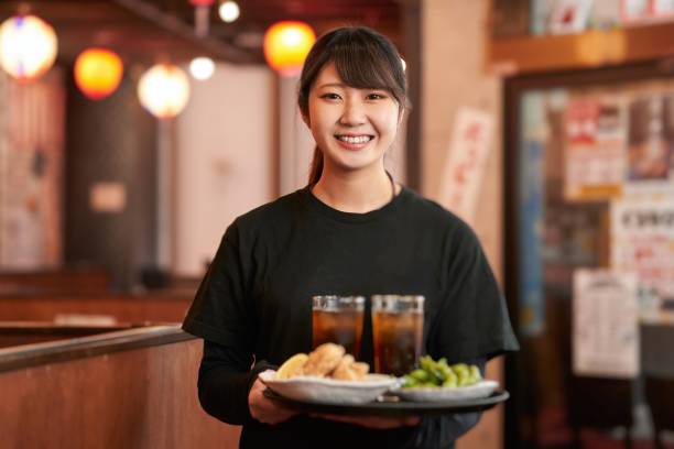 Job image of a woman working in a pub Recruitment image of a woman in her 20s working at a Japanese restaurant byte stock pictures, royalty-free photos & images
