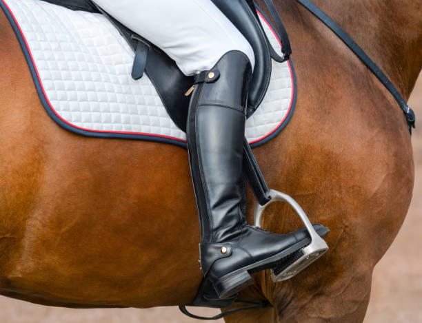 Jockey riding boot in the stirrup. Close up image of jockey riding boot in the stirrup. Rider on bay sport horse. stirrup stock pictures, royalty-free photos & images