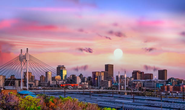 ヨハネスブルグの街のスカイラインとネルソンマンデラ橋の日没時 - 南アフリカ共和国 ストックフォトと画像