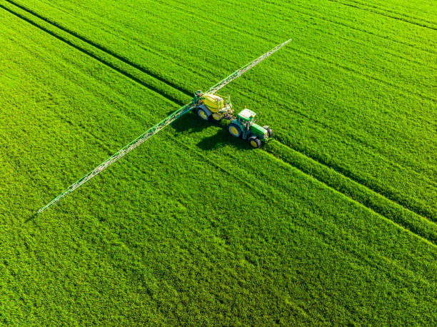 John Deere tractor with an agriculutural crops sprayer from above stock photo