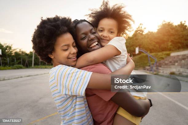 Joyful and caring sisters, embracing their mother, showing to her all love they have for her