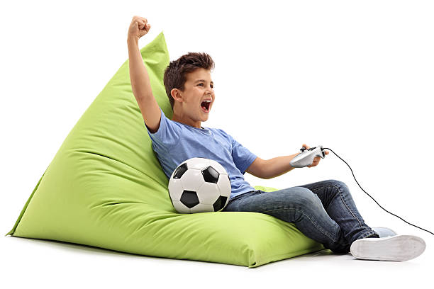 ragazzo gioioso che gioca a videogiochi di calcio - joystick soccer foto e immagini stock