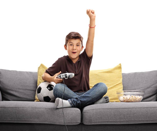 bambino gioioso che gioca a videogiochi di calcio - joystick soccer foto e immagini stock