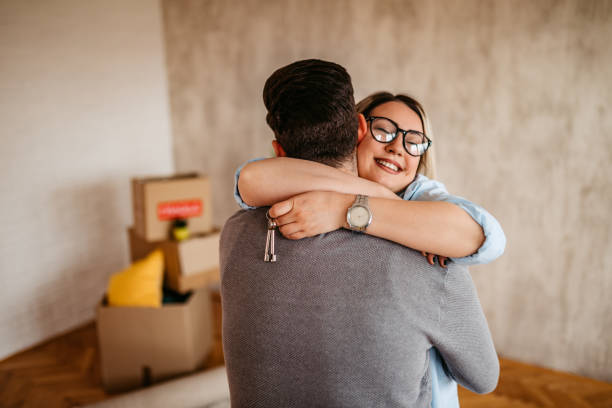 Joyful young couple embracing in new apartment stock photo