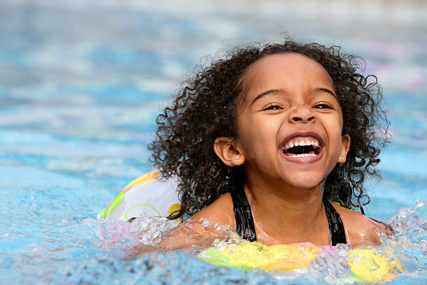 ein jubelnder kind schwimmen im pool - schwimmen stock-fotos und bilder